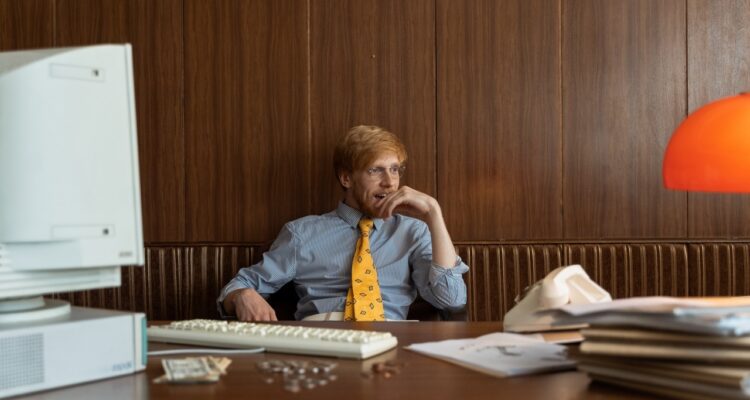 Homem sentado em seu escritório tentando vencer a procrastinação no trabalho