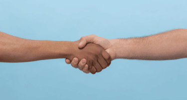 Imagem de duas mãos juntas em um aperto de mão para simbolizar outplacement