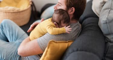 Imagem de um pai com um bebe no colo para simbolizar como funciona a licença paternidade